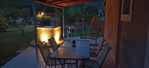 a table and chairs on a patio at night at VASIANA Country House in Razáta