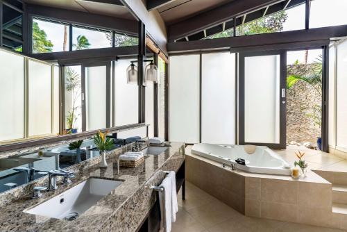 a bathroom with two sinks and a tub and windows at Shangri-La Yanuca Island, Fiji in Voua