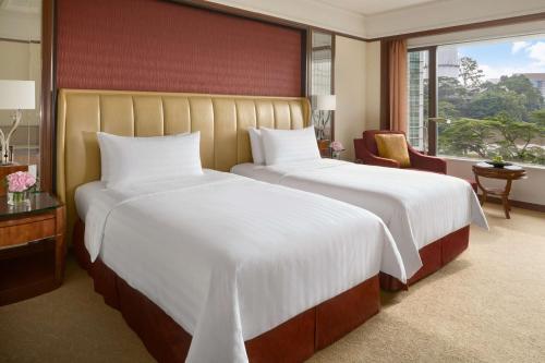 a hotel room with two beds and a window at Shangri-La Kuala Lumpur in Kuala Lumpur