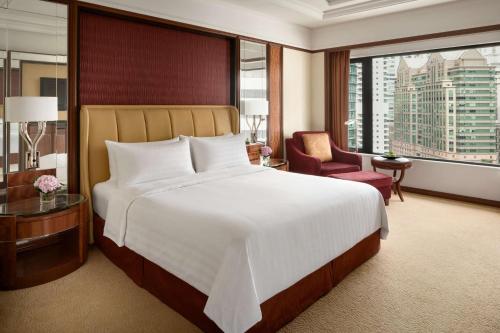 a hotel room with a large bed and a large window at Shangri-La Kuala Lumpur in Kuala Lumpur