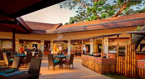 a restaurant with tables and chairs on a patio at Shangri-La Rasa Ria, Kota Kinabalu in Kota Kinabalu