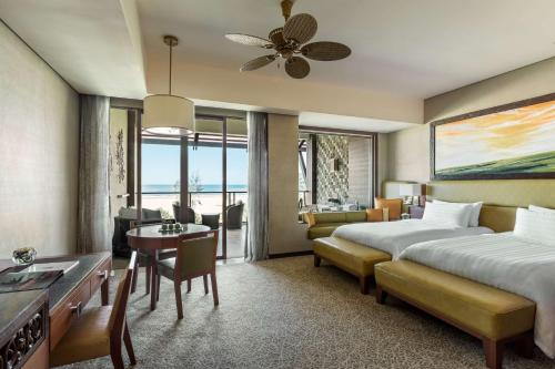 a hotel room with two beds and a living room at Shangri-La Rasa Ria, Kota Kinabalu in Kota Kinabalu
