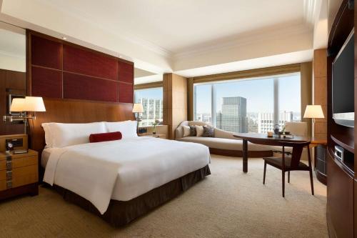 東京にあるShangri-La Tokyoのベッドと机とテレビのある寝室