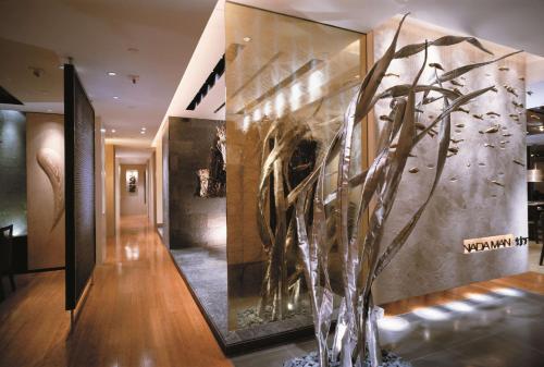 a room with a wall with a vase with a plant at Kowloon Shangri-La, Hong Kong in Hong Kong