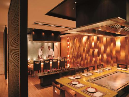 a restaurant with two men standing in the kitchen at Kowloon Shangri-La, Hong Kong in Hong Kong