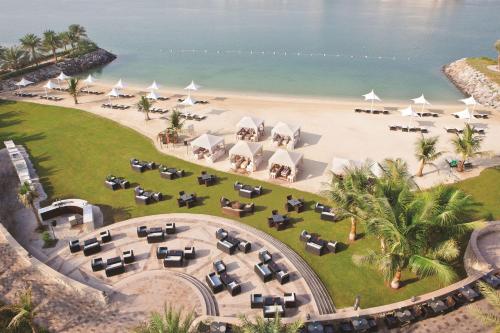 an overhead view of a beach with tables and white umbrellas at Traders Hotel, Abu Dhabi in Abu Dhabi