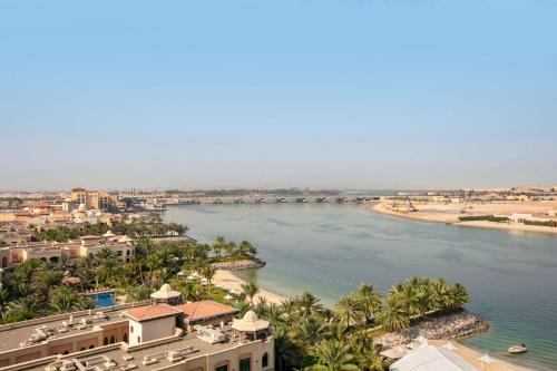 a view of a river with buildings and palm trees at Traders Hotel, Abu Dhabi in Abu Dhabi