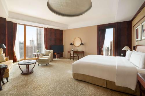 a hotel room with a large bed and a large window at Pudong Shangri-La Shanghai - With a sweeping view of the Pearl Tower and the historic Bund skyline in Shanghai
