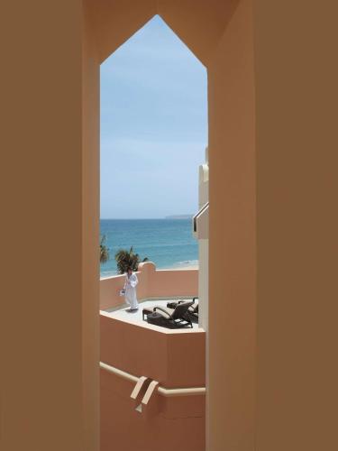 a room with a view of the beach through a doorway at Shangri-La Barr Al Jissah, Muscat in Muscat