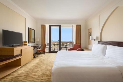 a hotel room with a bed and a television at Shangri-La Barr Al Jissah, Muscat in Muscat