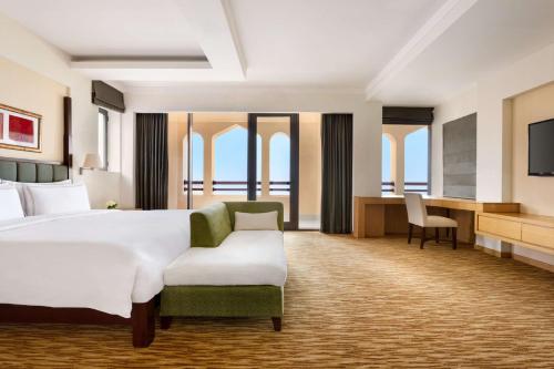 a hotel room with a large bed and a desk at Shangri-La Barr Al Jissah, Muscat in Muscat