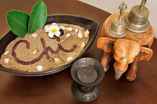 a table with a bowl of sand with a flower on it at Shangri-La Barr Al Jissah, Muscat in Muscat