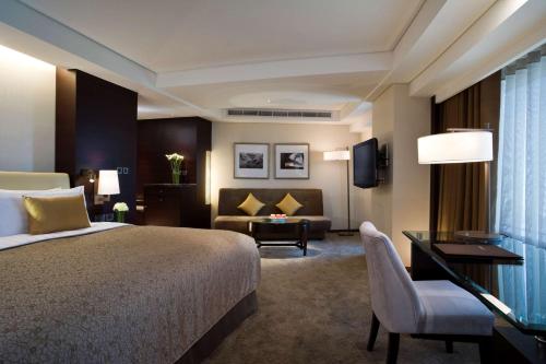 a hotel room with a bed and a desk at Shangri-La Far Eastern Tainan in Tainan