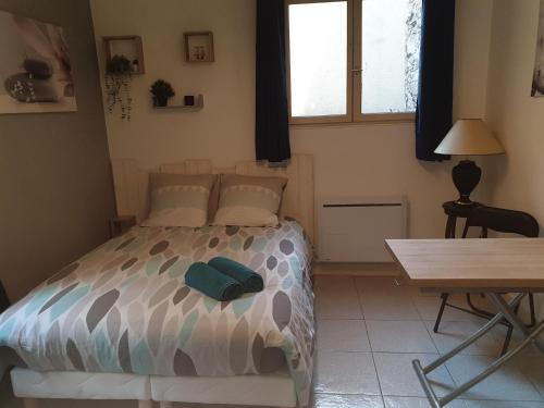 a bedroom with a bed and a table and a desk at Le Senlipin, studio centre ville, coeur de Senlis, proche parc Asterix in Senlis