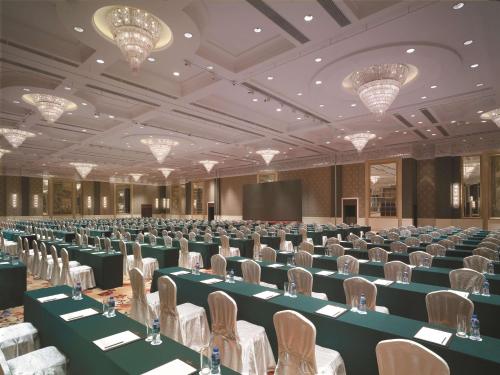 a large room with tables and chairs and a screen at Shangri-La Wuhan,Close to The Mixc with three subway lines in Wuhan