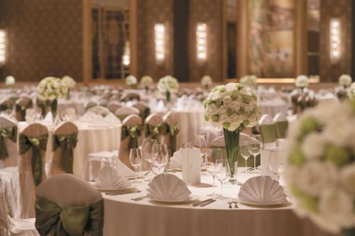 a room filled with tables with white flowers and chairs at Shangri-La Wuhan,Close to The Mixc with three subway lines in Wuhan