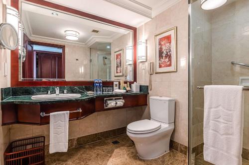 a bathroom with a toilet and a sink and a mirror at Shangri-La Wuhan,Close to The Mixc with three subway lines in Wuhan