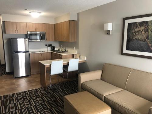 a living room with a couch and a kitchen at Microtel Inn & Suites by Wyndham Sudbury in Sudbury