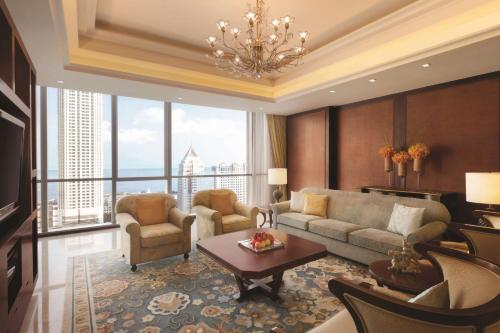 a living room with a couch and chairs and a large window at Shangri-La Qingdao - May Fourth Square in Qingdao