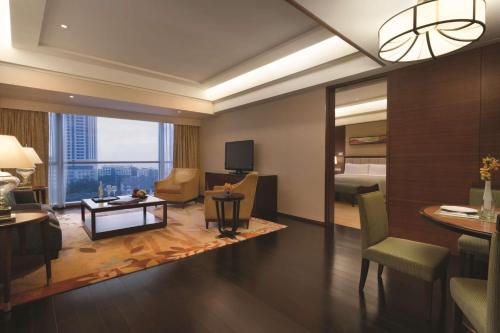 a hotel room with a living room with a view at Shangri-La Qingdao - May Fourth Square in Qingdao