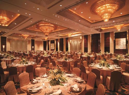 a large banquet hall with tables and chairs and chandeliers at Shangri-La Qingdao - May Fourth Square in Qingdao