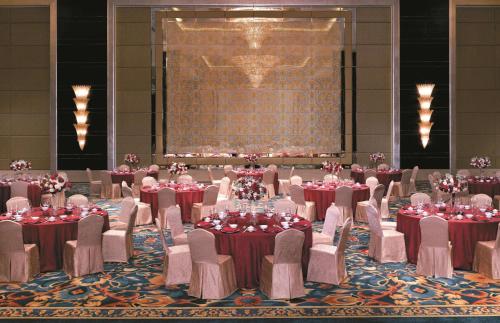 a banquet hall with tables and chairs and a large screen at Shangri-La Qingdao - May Fourth Square in Qingdao