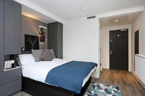 a bedroom with a large bed with a blue blanket at JOIVY at VITA Fountainbridge - Adults only - Breakfast buffet in Edinburgh