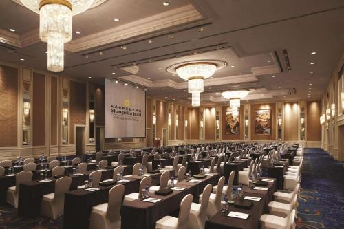 a conference room with tables and chairs and a screen at Shangri-La Changchun in Changchun