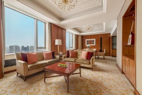 a living room with couches and a table at Shangri-La Huhhot in Hohhot