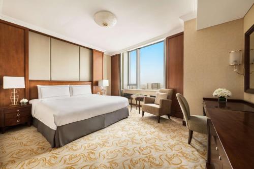 a hotel room with a bed and a desk at Shangri-La Huhhot in Hohhot