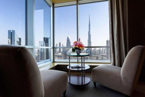 a room with a large window with a table with flowers at Shangri-La Dubai in Dubai