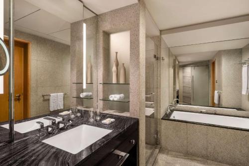 a bathroom with a sink, mirror, and bathtub at Shangri-La Dubai in Dubai