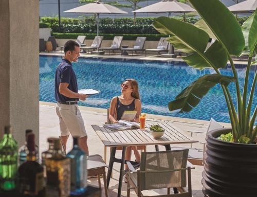 a man and a woman sitting at a table with a frisbee at Makati Shangri-La, Manila in Manila