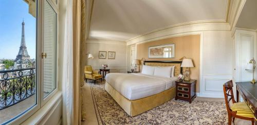 a bedroom with a bed and a balcony with the eiffel tower at Shangri-La Paris in Paris