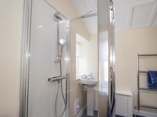 a bathroom with a shower and a sink at Balnaird Farmhouse in Strathpeffer
