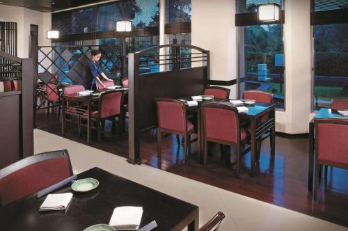 a person sitting at a table in a restaurant at Shangri-la Surabaya in Surabaya