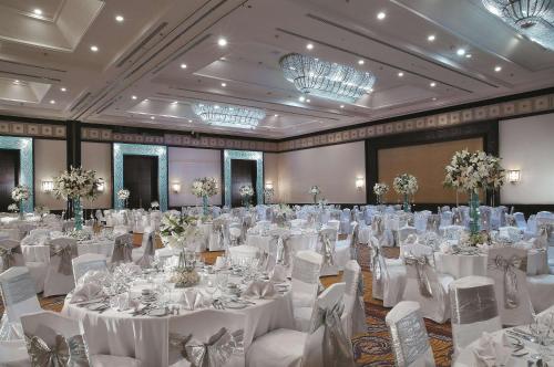 a banquet hall with white tables and white chairs at Shangri-la Surabaya in Surabaya