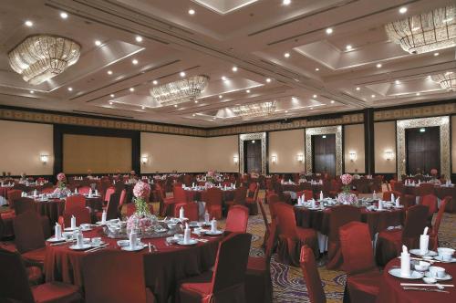 a large banquet room with tables and chairs and chandeliers at Shangri-la Surabaya in Surabaya