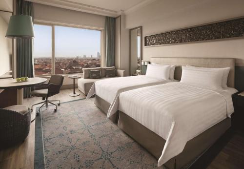 a hotel room with a large bed and a large window at Shangri-la Surabaya in Surabaya