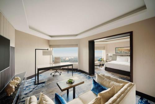 a living room with a bed and a desk in a room at Shangri-La Eros New Delhi in New Delhi