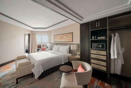 a bedroom with a large white bed and a chair at Shangri-La Eros New Delhi in New Delhi