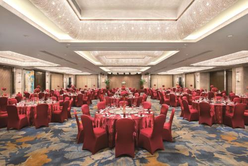 a large banquet hall with tables and red chairs at Shangri-La Shenzhen - Nearby Luohu Border, Outdoor Swimming Pool in Shenzhen