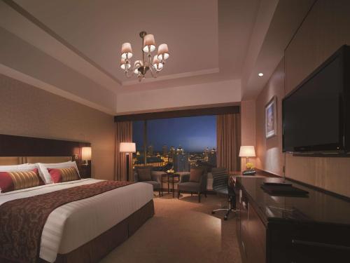 a hotel room with a bed and a large window at Shangri-La Manzhouli in Manzhouli