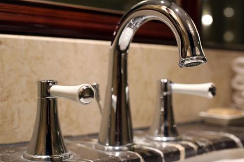 a kitchen sink with two faucets on a counter at Shangri-La Manzhouli in Manzhouli