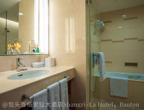 a bathroom with a sink and a shower at Shangri-La Baotou in Baotou