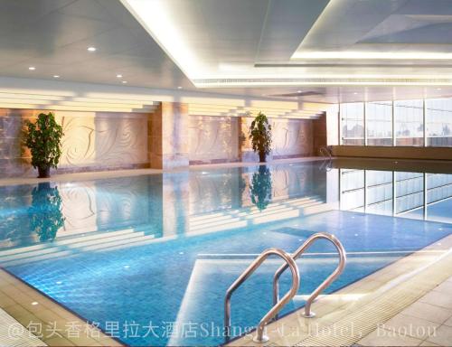a large swimming pool in a building at Shangri-La Baotou in Baotou