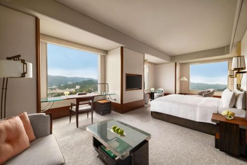 a hotel room with a bed and a large window at Shangri-La Far Eastern, Taipei in Taipei