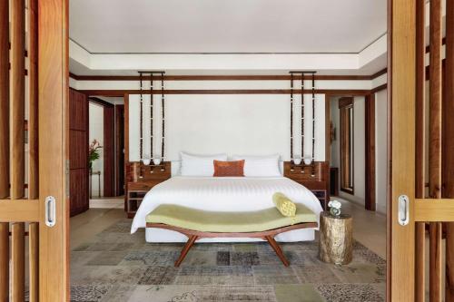 a bedroom with a bed and a dresser at Shangri-La Le Touessrok, Mauritius in Trou d'Eau Douce