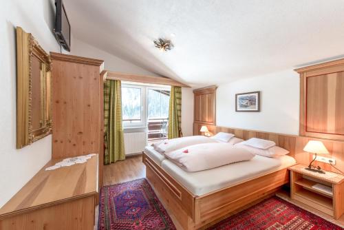 1 dormitorio con cama y ventana en Ferienwohnungen & Chalets Capricorno, en Mittelberg