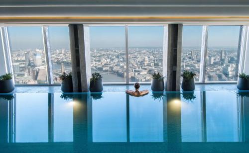 una persona sentada en una piscina en un edificio en Shangri-La The Shard, London, en Londres